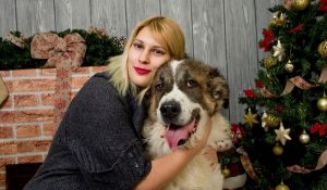 dog with girl beside Christmas tree